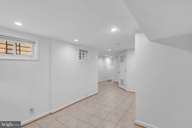 basement with recessed lighting, baseboards, and light tile patterned floors