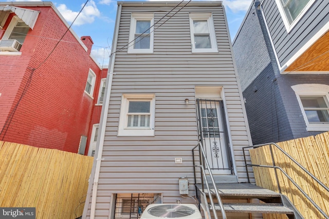 rear view of house with fence and cooling unit