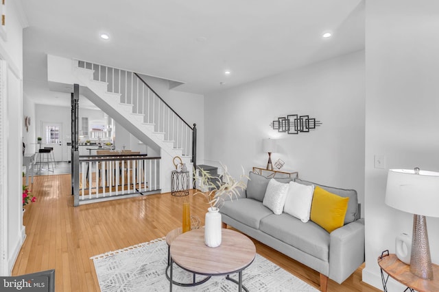 living area with stairs, recessed lighting, and wood finished floors