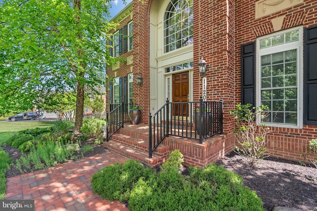 doorway to property featuring brick siding