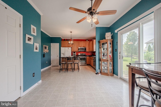 dining space with crown molding, baseboards, and ceiling fan