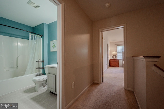 interior space featuring shower / bath combo with shower curtain, toilet, baseboards, visible vents, and vanity