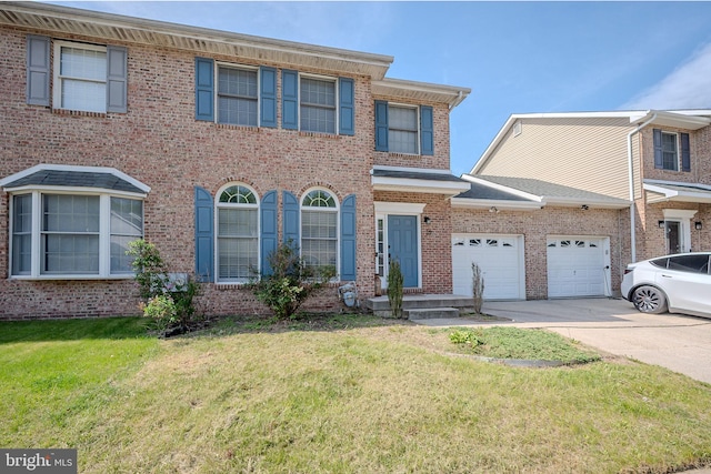 colonial inspired home with a garage, a front lawn, brick siding, and driveway