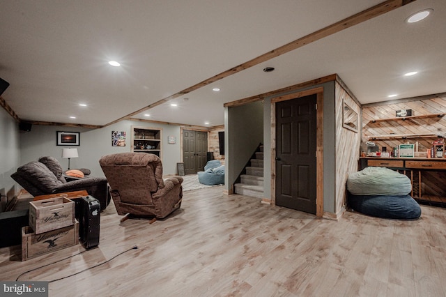 living area featuring stairs, wood walls, recessed lighting, and wood finished floors
