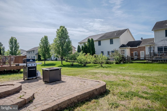 view of yard featuring an outdoor fire pit, a patio, a residential view, and a deck