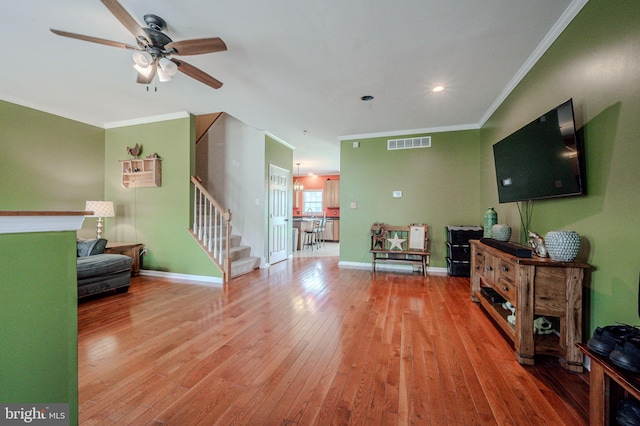 living area with a ceiling fan, stairs, wood-type flooring, and visible vents