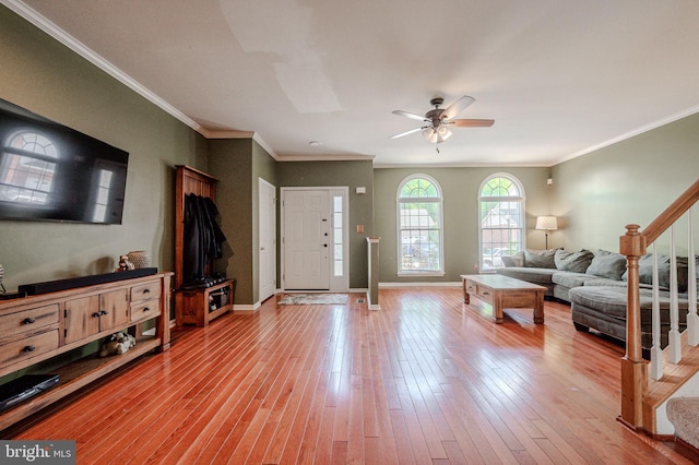 living room featuring a ceiling fan, stairs, baseboards, and light wood finished floors