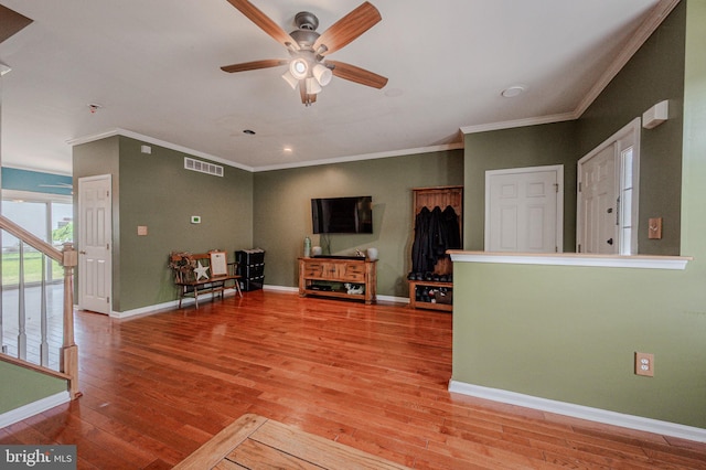 living area with light wood-type flooring, ornamental molding, a ceiling fan, and visible vents