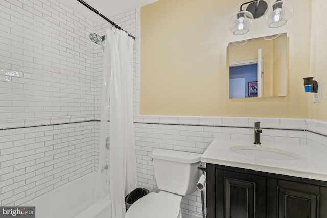 bathroom featuring tile walls, vanity, a wainscoted wall, toilet, and shower / tub combo with curtain