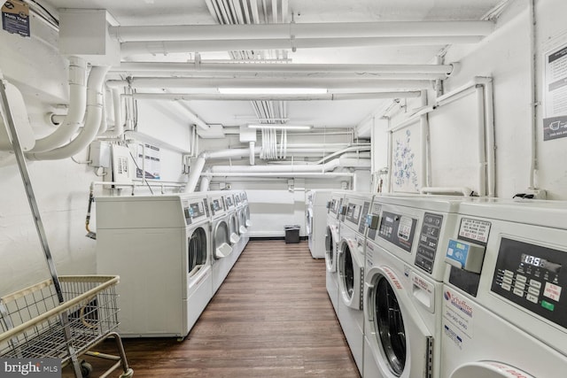 communal laundry room with separate washer and dryer and dark wood finished floors