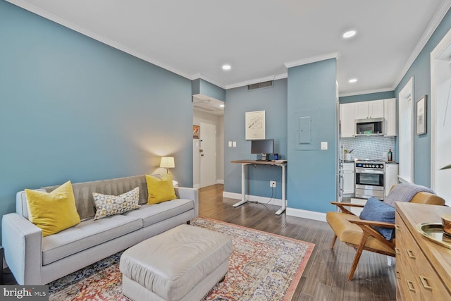 living room with ornamental molding, recessed lighting, wood finished floors, and baseboards