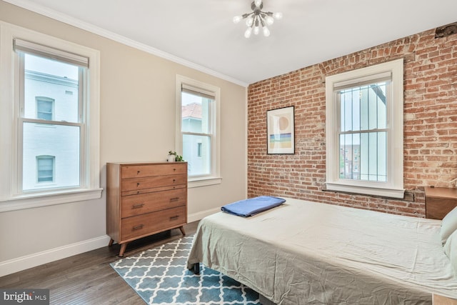 bedroom featuring baseboards, multiple windows, wood finished floors, crown molding, and brick wall