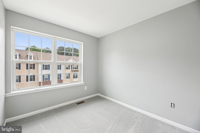 carpeted empty room featuring baseboards