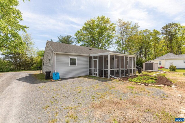 654 Bybee Rd, Louisa, VA 23093 - rear view of house with a sunroom, a storage shed, an outbuilding, and driveway