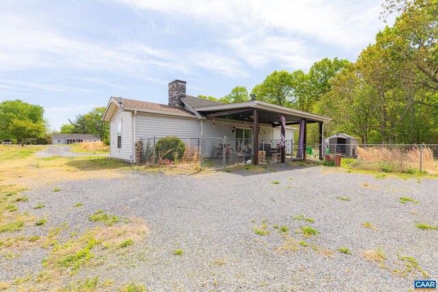 654 Bybee Rd, Louisa, VA 23093 - view of front facade with fence, a chimney, a gate, an outdoor structure, and a storage unit