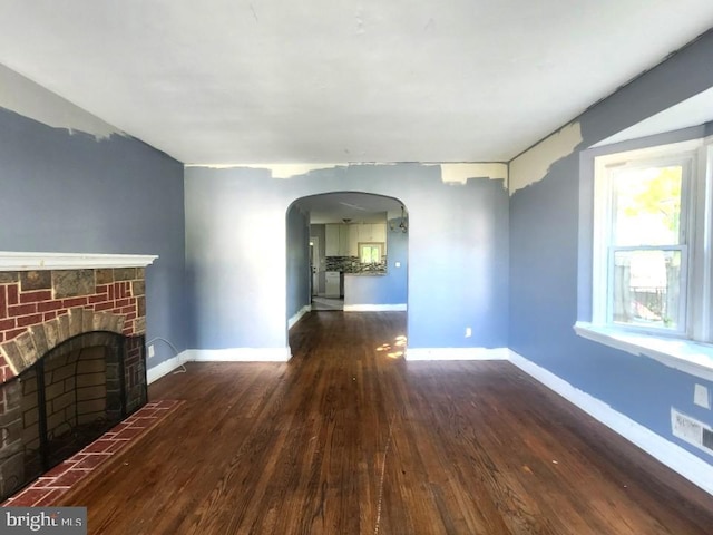 4503 Lasalle Ave, Baltimore, MD 21206 - unfurnished living room featuring arched walkways, baseboards, a fireplace, and wood-type flooring