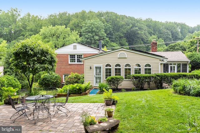 8108 Beech Tree Rd, Bethesda, MD 20817 - back of house featuring a lawn, a patio, a chimney, and brick siding
