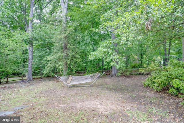 view of yard with fence and a forest view