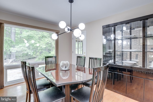 dining area featuring light wood finished floors and a chandelier