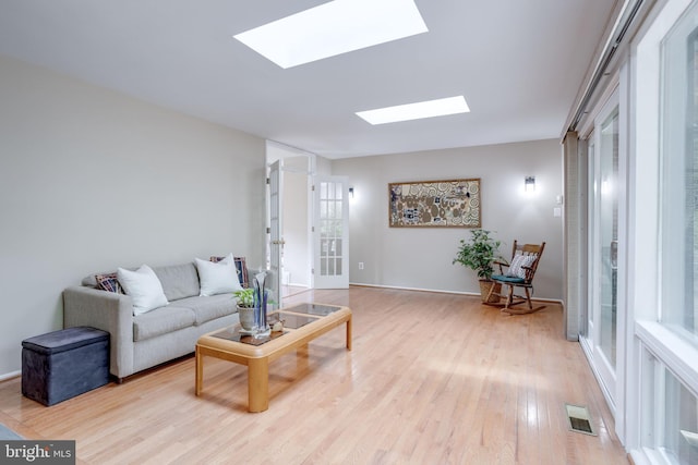 living room with a skylight and light wood finished floors