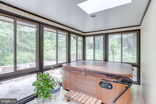 sunroom / solarium with a hot tub, a skylight, and tile patterned flooring