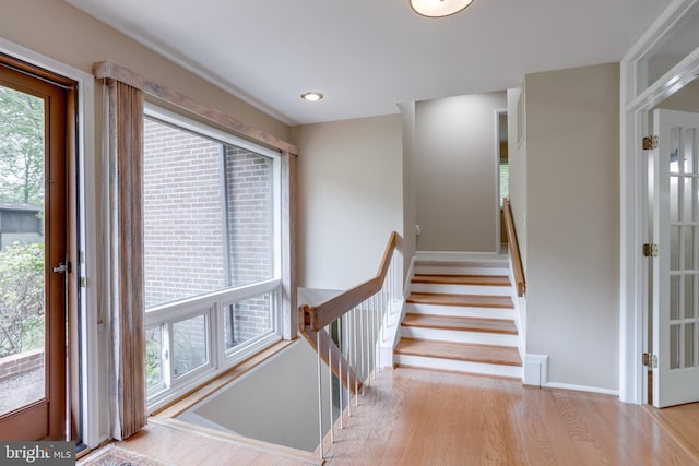 staircase with wood finished floors and baseboards