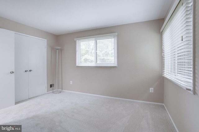 unfurnished bedroom with carpet, a closet, and baseboards