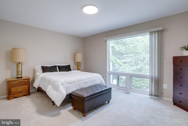 carpeted bedroom featuring multiple windows and baseboards