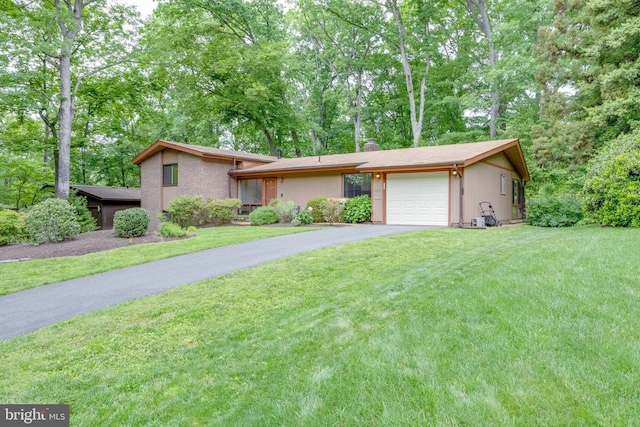 view of front facade with a garage, driveway, a front yard, and a chimney