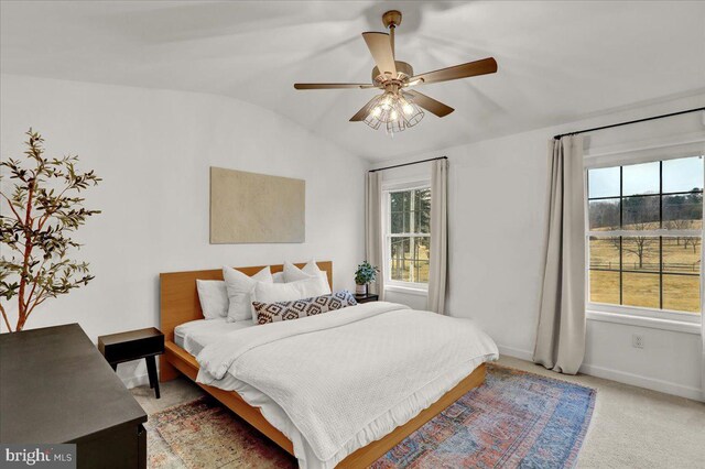 bedroom with lofted ceiling, baseboards, carpet, and ceiling fan