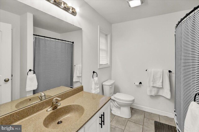bathroom featuring tile patterned flooring, vanity, toilet, and baseboards