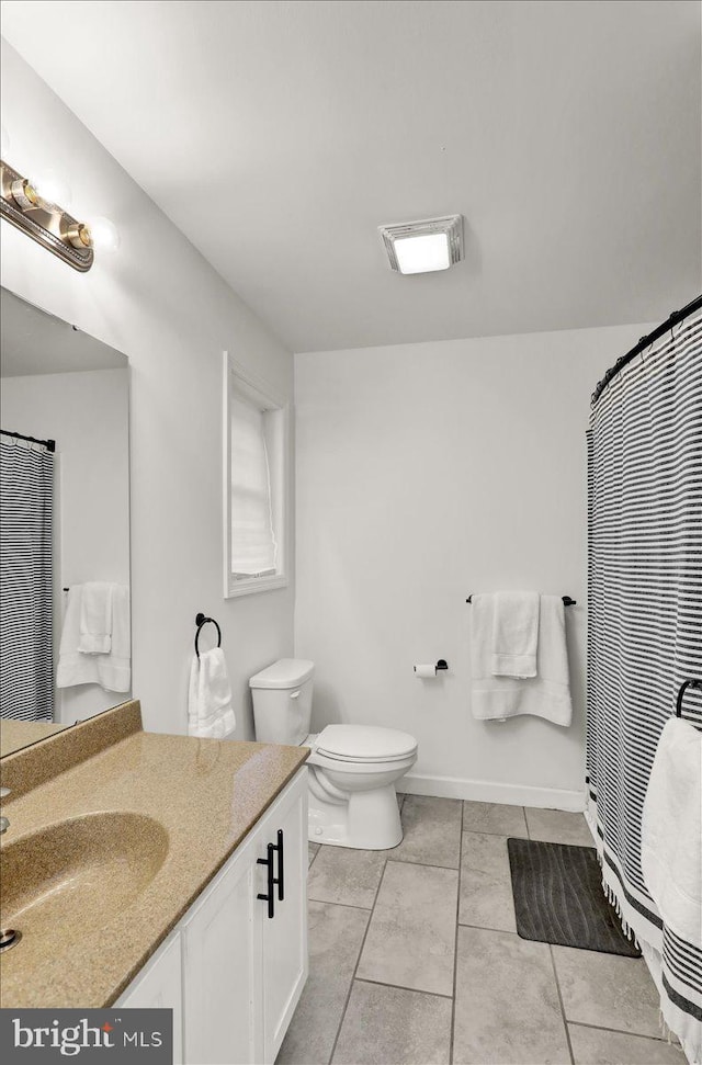 full bathroom with tile patterned floors, vanity, toilet, and baseboards