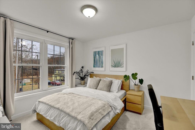 bedroom featuring light carpet and baseboards
