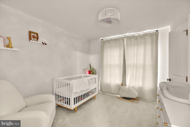 carpeted bedroom with a crib and a sink