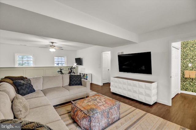 living area featuring wood finished floors, baseboards, and ceiling fan
