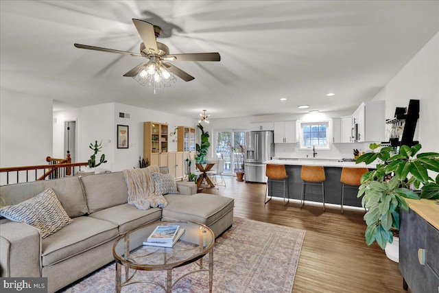 living room with dark wood finished floors, a ceiling fan, and recessed lighting