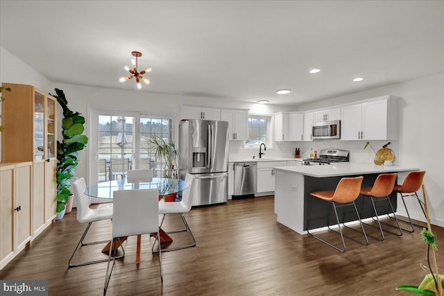 kitchen with stainless steel appliances, a sink, decorative backsplash, light countertops, and white cabinets