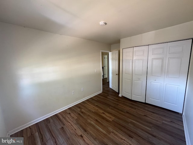 1165 S Division St, Salisbury, MD 21804 - unfurnished bedroom featuring baseboards, a closet, and dark wood-type flooring