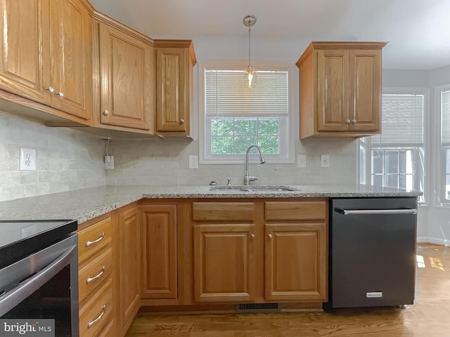 kitchen featuring a sink, light stone counters, visible vents, dishwasher, and decorative backsplash