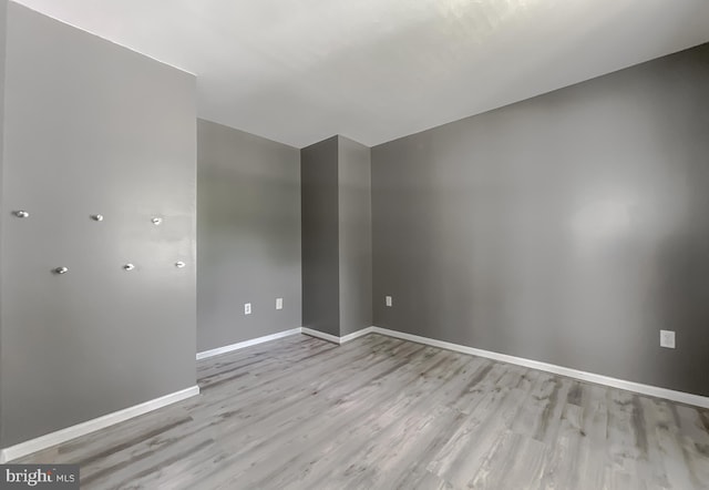 empty room featuring light wood-style flooring and baseboards