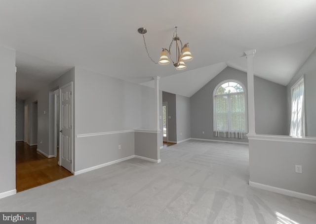 unfurnished room featuring carpet, baseboards, lofted ceiling, and an inviting chandelier
