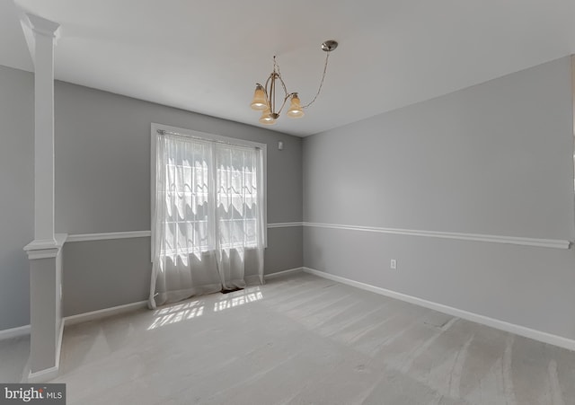 unfurnished room with a chandelier, baseboards, ornate columns, and carpet floors