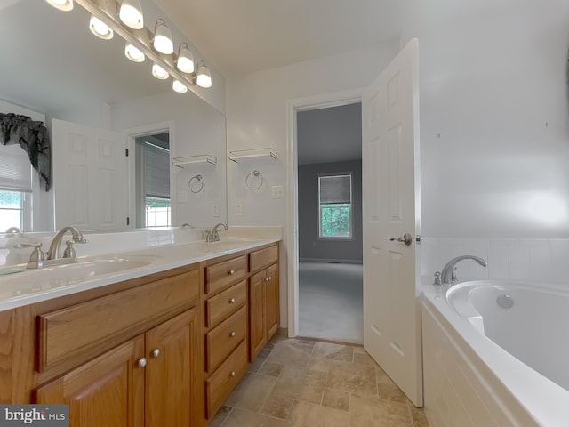 full bath with double vanity, a bath, stone finish floor, and a sink