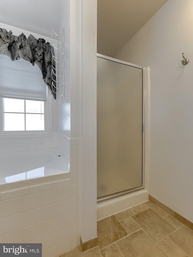 bathroom featuring a garden tub and a shower stall