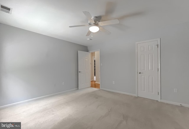 unfurnished bedroom featuring light colored carpet, visible vents, baseboards, and ceiling fan