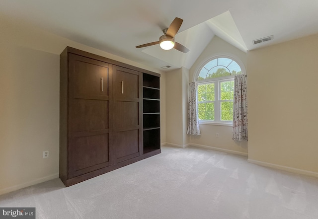 unfurnished bedroom with vaulted ceiling, light carpet, baseboards, and visible vents