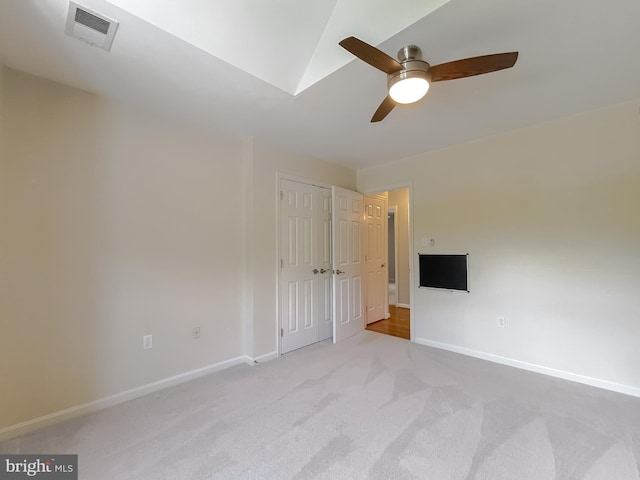 unfurnished bedroom featuring a closet, visible vents, light carpet, a ceiling fan, and baseboards