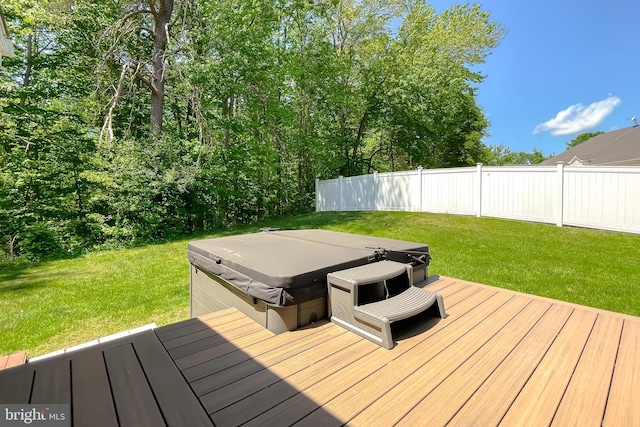 wooden terrace featuring a hot tub, fence, and a yard