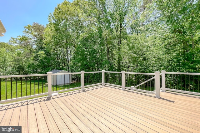 wooden deck featuring a storage unit, an outdoor structure, and a yard