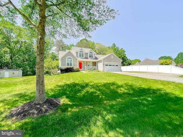 view of front of property featuring concrete driveway, a front lawn, a garage, and fence
